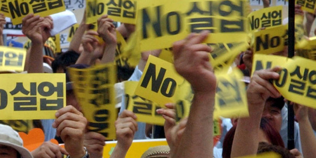 Jobless workers show a cards during an anti-government rally demanding job security at a park in Seoul, Friday, June 11, 2004. The nation's employment capacity dipped to the worst level in six years since the financial crisis six years ago as the economy loses momentum to generate extra jobs in accordance with growth. The letters on the cards read " Unemployment ".(AP Photo/Ahn Young-joon).
