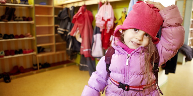 Little girl in nursery with anorak and cap