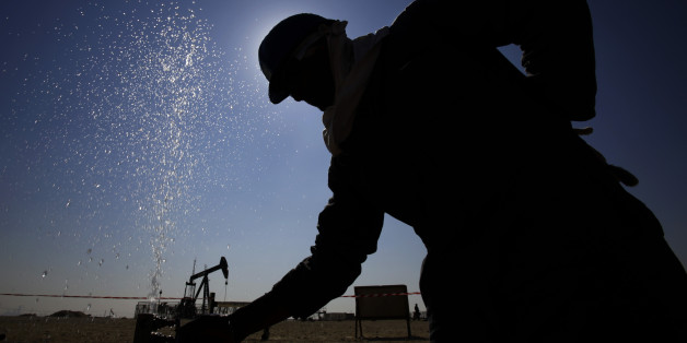 An oil worker adjusts a valve releasing a spray of water while working on oil pipelines Thursday, Feb. 18, 2016, in the desert oil fields of Sakhir, Bahrain. Iran appeared Wednesday to back a plan laid out by four influential oil producers to cap their crude output if others do the same, though it offered no indication that it has any plans to follow suit itself. The agreement reached in Doha the day before by Qatar, Saudi Arabia, Russia and Venezuela is aimed at stabilizing global oil prices. (
