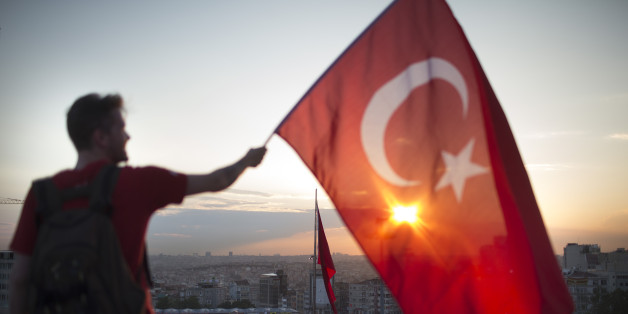 Ein Mann zeigt auf einer Demonstration die türkische Flagge