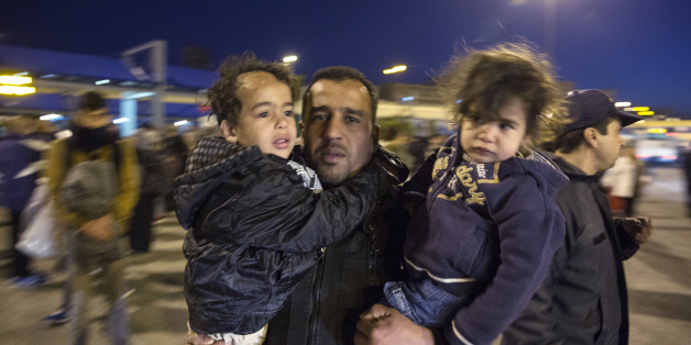 A man carrying two children arrives at the port of Piraeus, near Athens, on Saturday, Feb. 20, 2016. EU leaders at a summit in Brussels made little headway in the elusive search for joint solutions to the influx of refugees and other migrants, though they did agree to hold a meeting in early March with Turkey. (AP Photo/Yorgos Karahalis)