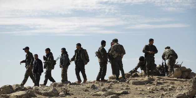 Fighters from the Syrian Democratic Forces (SDF) gather on the outskirts of the town of Chaddade in the northeastern Syrian province of Hasaka, on February 19, 2016.The Syrian Democratic Forces (SDF), an alliance dominated by the Kurdish People's Protection Units (YPG), seized on Friday the town of Chaddade, a bastion of the Islamic State group (IS) in the Hasaka province, in northeastern Syria, according to the Syrian Observatory for Human Rights. / AFP / Delil souleiman (Photo credit sh