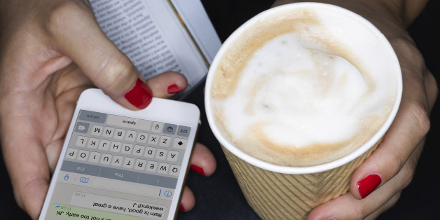 Female holding take away coffee, texting, close up