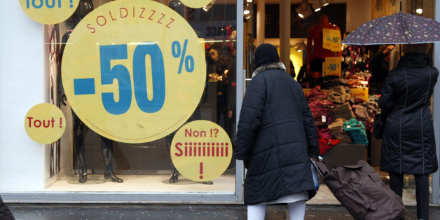 A woman looks at a shop with "Soldes", Sales written on the window in Paris, France, Wednesday, Jan. 12, 2011. Parisians search over the bargain bin for deals as during the winter sales in France. (AP Photo/Francois Mori)