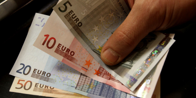 A customer receives euro notes in a counter at the Bank of Greece headquarters in Athens, Thursday, April 8, 2010. Greece's borrowing costs spiked higher for a third day Thursday, intensifying the country's debt crisis and suggesting a eurozone rescue program is providing little support. (AP Photo/Thanassis Stavrakis)