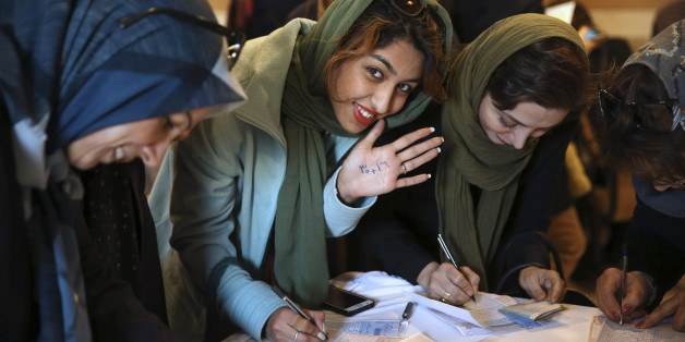 An Iranian woman displays her ink-stained finger after voting in the parliamentary and Experts Assembly elections at a polling station in Qom, 125 kilometers (78 miles) south of the capital Tehran, Iran, Friday, Feb. 26, 2016. Polls opened Friday in Iran's parliamentary elections, the country's first since its landmark nuclear deal with world powers last summer. (AP Photo/Ebrahim Noroozi)