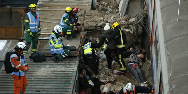 Evaluators on the roof of a container watch to see how members of the emergency services treat simulated casualties during an exercise run by the London Fire Brigade at a disused power station in east London, Monday, Feb. 29, 2016. The exercise involving the London emergency services is set around a building collapse onto a major London underground railway station. (AP Photo/Alastair Grant)