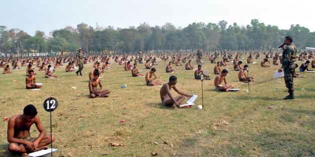 Indian army candidates sit in their underwear in a field as they take a written exam after being asked to remove their clothing to deter cheating during a recruitment day in Muzaffarpur on February 28, 2016. India's army made candidates at a recruitment day in Bihar take a written exam in their underwear to prevent them from cheating, reports said March 1, after a spate of exam cheating scandals in the eastern state. AFP PHOTO / STR / AFP / STRDEL (Photo credit should read STRDEL/AFP/Getty Images)