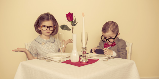 A young boy has a conversation online instead of with his lovely date.