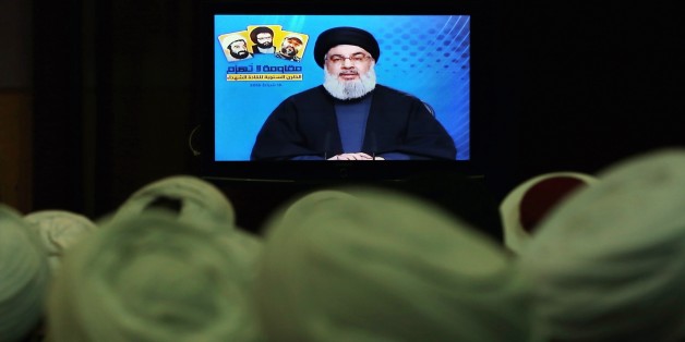 FILE- In this Tuesday, Feb. 16, 2016 file photo, Shiite and Sunni clerics listen to Hezbollah leader Sayyed Hassan Nasrallah as he speaks via a video link, during a ceremony to honer fallen Hezbollah leaders, in the southern suburbs of Beirut, Lebanon. A Saudi-led bloc of six Gulf Arab nations formally branded Hezbollah a terrorist organization on Wednesday, ramping up the pressure on the Lebanese militant group fighting on the side of President Bashar Assad in Syria. (AP Photo/Bilal Hussein, File)