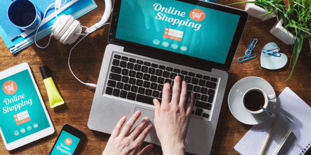Online shopping website on laptop screen with female hands typing