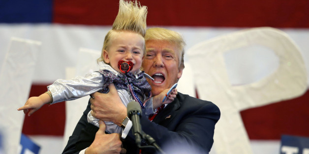 Republican presidential candidate Donald Trump holds up a child he pulled from the crowd as he arrives to speak at a campaign rally in New Orleans, Friday, March 4, 2016. (AP Photo/Gerald Herbert)