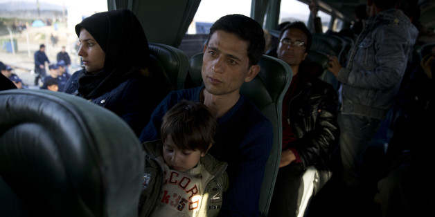 An Afghan family sit inside a bus as they leave with others the northern Greek border station of Idomeni, on Tuesday, Feb. 23, 2016. In an early morning operation, police at the Greek-Macedonian border ordered mostly Afghan migrants onto buses bound for Athens. The migrants are being taken to an army-built camp near Athens that was set up last week, following European Union pressure on Athens to complete screening and temporary housing facilities. (AP Photo/Petros Giannakouris)