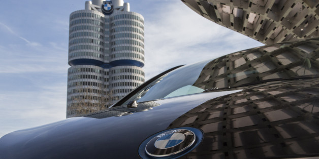 A BMW i3 plug-in automobile, produced by Bayerische Motoren Werke AG, sits outside the BMW World showroom as the automaker's headquarter towers stand beyond in Munich, Germany, on Tuesday, Jan. 26, 2016. BMW is at risk of losing its lead in the luxury car market this year to Mercedes-Benz after reporting the slowest sales growth since 2009 while its German arch-rival charged ahead with a fresher lineup and surging demand in China. Photographer: Martin Leissl/Bloomberg via Getty Images