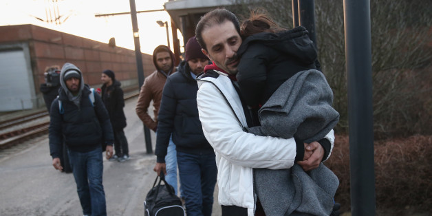 Während Einheimische starren, helfen Flüchtlinge einer jungen Frau nach einem Autounfall.