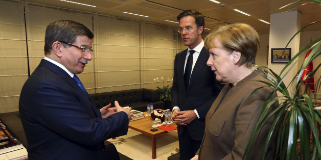 Turkey's Prime Minister Ahmet Davutoglu, left, listens to Germany's Chancellor Angela Merkel, right as Mark Rutte, centre, Prime Minister of Netherlands, looks on, during their meeting at Turkey's permanent delegation to the European Union, in Brussels, late Sunday, March 6, 2016. (Hakan Goktepe/Prime Minister's Press Service, Pool Photo via AP)