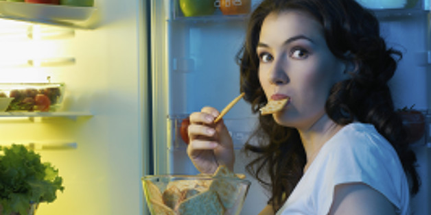 a hungry girl opens the fridge