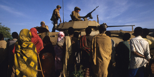 December 16, 1992. Baidoa, Somalia. US Marines atop a Bradley tank are seen delivering food aid to the famine stricken people of the Somali countryside. Late in 1992, troops from the United States and other nations attempted to restore political stability
