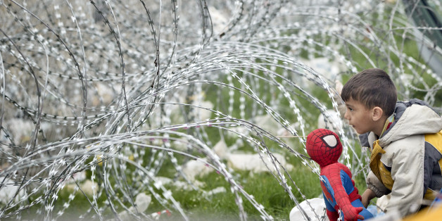 A boy plays with a Spiderman doll next to the razor wire around the fence between Greece and Macedonia at the northern Greek border station of Idomeni, Monday, March 7, 2016. Greek police officials say Macedonian authorities have imposed further restrictions on refugees trying to cross the border, saying only those from cities they consider to be at war can enter as up to 14,000 people are trapped in Idomeni, while another 6,000-7,000 are being housed in refugee camps around the region.(AP Phot
