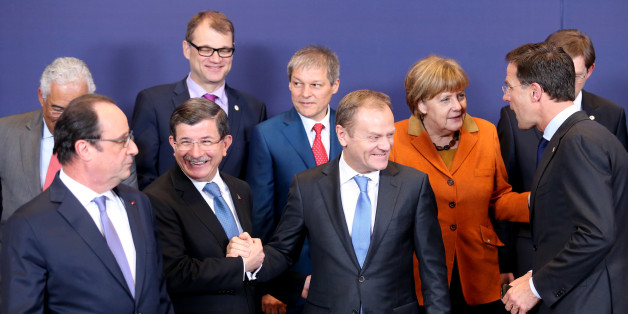 European Council President Donald Tusk, front center, shakes hands with Turkish Prime Minister Ahmet Davutoglu, front second left, during a group photo at an EU summit in Brussels on Monday, March 7, 2016. European Union leaders are holding a summit in Brussels on Monday with Turkey to discuss the current migration crisis. Other leaders left to right, Portuguese Prime Minister Antonio Costa, French President Francois Hollande, Finnish Prime Minister Juha Sipila, Romanian Prime Minister Dacian Ciolos, German Chancellor Angela Merkel, Dutch Prime Minister Mark Rutte and Slovenian Prime Minister Miro Cerar. (AP Photo/Francois Walshaerts)