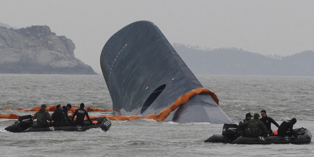 FILE - In this April 17, 2014 file photo, South Korean Coast Guard personnel search for missing passengers aboard the sunken ferry Sewol in the waters off the southern coast near Jindo, South Korea. Salvaging the corroded, the 6,800-ton ferry Sewol from deep beneath a channel notorious for dangerous currents will be difficult, expensive and potentially risky. It will also be one more major headache for a government already reeling from accusations that its incompetence and corruption were partly