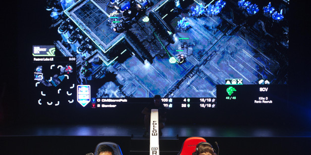 FILE - In this July 13, 2014 file photo, Choi Seong Hun, left, who goes by the gaming name "PoLt" and Choi Ji Sung, known as "Bomber," both of South Korea, are separated by a divider as they compete against each other in the finals of the Red Bull Battle Grounds "StarCraft II" video game tournament in Atlanta. The next ally in competitive gamingâs fight for mainstream awareness might be marketers. At an invite-only gathering of marketing executives Wednesday, May 6, 2015, representatives fr