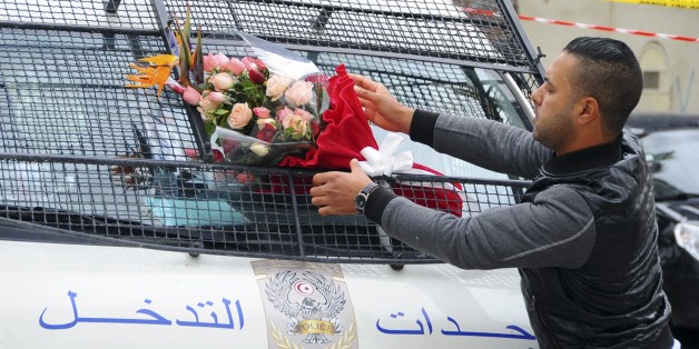 Le 25 novembre 2015, un homme place des fleurs sur un véhicule de police, à proximité des lieux de l'attentat ayant visé la garde présidentielle, 13 personnes.
