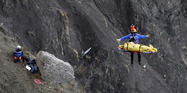 FOR USE AS DESIRED, YEAR END PHOTOS - FILE - A rescue worker is lifted into an helicopter at the crash site near Seyne-les-Alpes, France, Thursday, March 26, 2015. The co-pilot of a Germanwings jet barricaded himself in the cockpit and rammed the plane full speed into the French Alps, ignoring the captain's frantic pounding on the cockpit door and the screams of terror from passengers. In a split second, he killed all 150 people aboard the plane. (AP Photo/Laurent Cipriani, File)