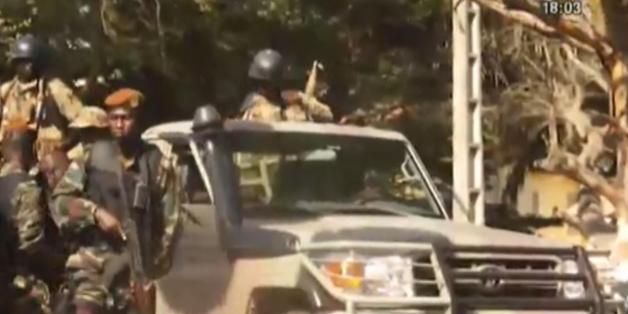 This image made available by RTI via Associated Press television shows various soldiers beside a military vehicle close to a beach in Grand-Bassam, Ivory Coast, Sunday March 13, 2016. At least six armed men attacked beachgoers outside three hotels Sunday in Grand-Bassam, killing several civilians and special forces, sending tourists fleeing through the historic Ivory Coast resort town. Bloody bodies were sprawled on the beach before being taken away by security forces and Ivorian Red Cross work