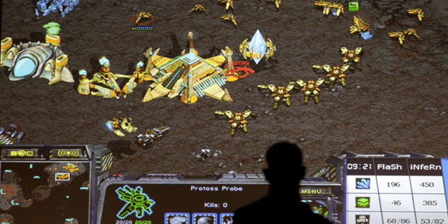 A man watches a StarCraft match between Young-Ho Lee, of South Korea, and Patrick Moeller, of Germany, at the 10th annual World Cyber Games in Los Angeles, Thursday, Sept. 30, 2010. (AP Photo/Jae C. Hong)