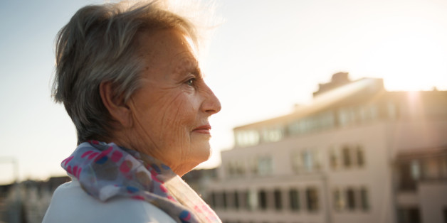 Senior woman standing on a roofgarden.