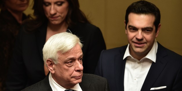 Turkey's Prime Minister Ahmet Davutoglu, right, hands translation headphones to Greece's Prime Minister Alexis Tsipras, prior to a joint news conference, after their meeting, in Izmir, Turkey, Tuesday, March 8, 2016. Turkey and Greece held holding talks on bilateral issues but also discussed the migrantsâ crisis a day after EU leaders agreed in principle on the outlines of a possible deal with Turkey for the return of thousands of migrants to Turkey. (AP Photo/Lefteris Pitarakis, Pool)
