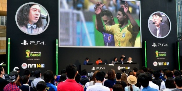 Des fans assistent, sur un écran géant, à un match de foot sur PlayStation à Tokyo, le 4 juin 2014