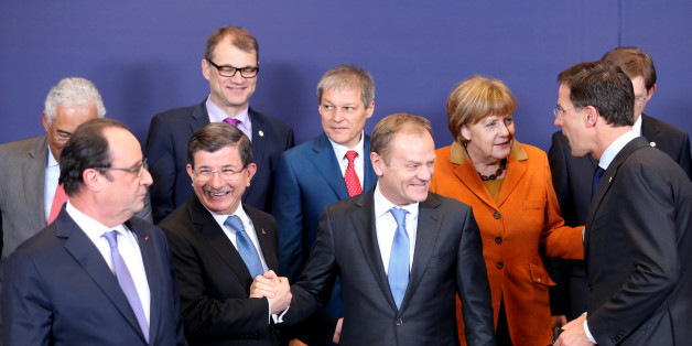European Council President Donald Tusk, front center, shakes hands with Turkish Prime Minister Ahmet Davutoglu, front second left, during a group photo at an EU summit in Brussels on Monday, March 7, 2016. European Union leaders are holding a summit in Brussels on Monday with Turkey to discuss the current migration crisis. Other leaders left to right, Portuguese Prime Minister Antonio Costa, French President Francois Hollande, Finnish Prime Minister Juha Sipila, Romanian Prime Minister Dacian Ciolos, German Chancellor Angela Merkel, Dutch Prime Minister Mark Rutte and Slovenian Prime Minister Miro Cerar. (AP Photo/Francois Walshaerts)