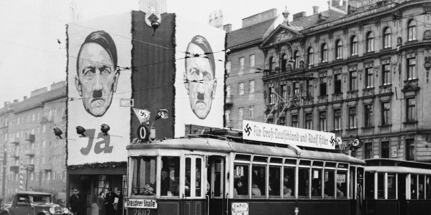 Huge pictures of Reichsfuehrer Adolf Hitler and slogans reading "For Greater Germany and Hitler" on streetcars are shown in Vienna, April 10, 1938. (AP Photo)