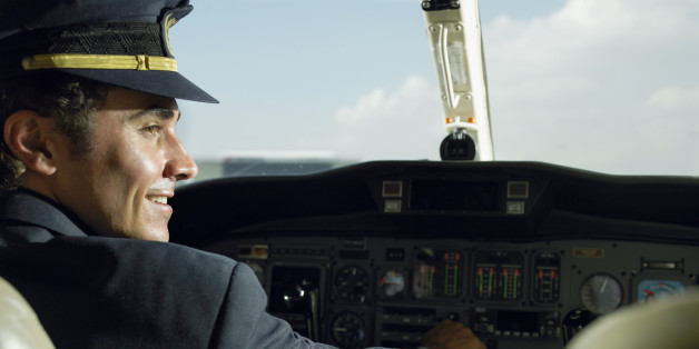 Pilot smiling in plane, side view
