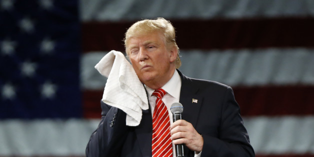 Republican presidential candidate Donald Trump wipes his cheek as he listens to a question from an audience member at a campaign event in Tampa, Fla., Monday, March 14, 2016. (AP Photo/Gerald Herbert)