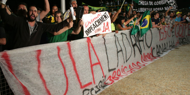 Demonstrators shout slogans from behind a banner that reads in Portuguese: "Lula thief," as they call for the impeachment of Brazil's President Dilma Rousseff and protest the naming of Lula da Silva as the president's new chief of staff, outside Planalto presidential palace in Brasilia, Brazil, Wednesday, March 16, 2016. Supporters say the move will help the president fight impeachment proceedings and critics blast it as a scheme to shield Lula from possible detention in corruption probes. (AP P