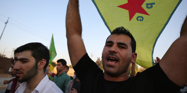 FILE - In this Saturday, July 25, 2015 file photo, a demonstrator waves the People's Protection Units flag, known as YPG, which is the main Kurdish fighting force in Syria, during a demonstration in Irbil, the Northern Kurdish region of Iraq. A spokesman for a powerful Syrian Kurdish political party said on Wednesday, March 16, 2016 that his faction is planning to declare a federal region in northern Syria, a model it hopes can be applied to the entire country. (AP Photo/Bram Janssen, File)
