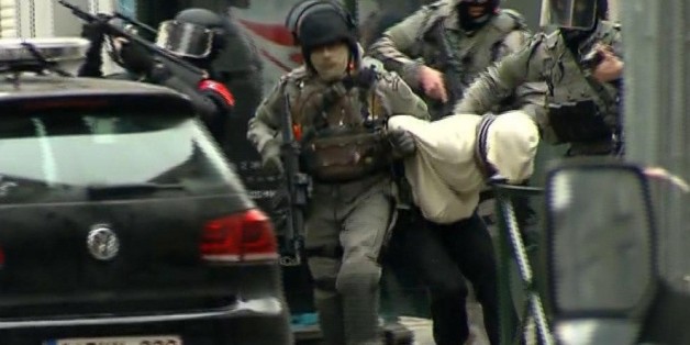 In this framegrab taken from VTM, armed police officers escort a suspect to a police vehicle during a raid in the Molenbeek neighborhood of Brussels, Belgium, Friday March 18, 2016. After an intense four-month manhunt across Europe and beyond, police on Friday captured Salah Abdeslam, the top fugitive in the Paris attacks in the same Brussels neighborhood where he grew up. (VTM via AP) BELGIUM OUT