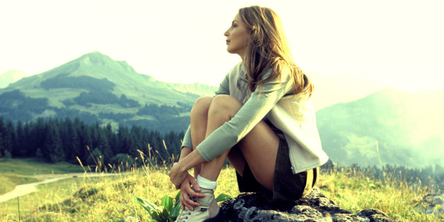 Woman sitting on mountainside