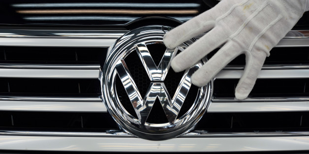 FILE - In this Oct. 23, 2015 file photo a worker touches the logo of Volkswagen AG on a Phaeton in Dresden, Germany. Volkswagen is reporting a loss of 1.67 billion euros (US dollar 1.83 billion) in the third quarter, Wednesday, Oct. 28, 2015, as earnings took a hit from 6.7 billion euros in set-asides for recalls and fines connected to cars rigged to evade U.S. diesel emissions testing. (Ralf Hirschberger/dpa via AP, file)