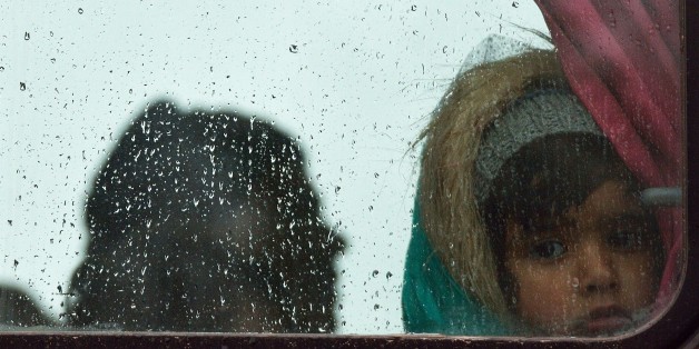 A child looks out a bus window as refugees are returned to a makeshift camp at the Greek-Macedonian border, near the Greek village of Idomeni, on March 15, 2016, where thousands of refugees and migrants are stranded by the Balkan border blockade.
Around 1,500 refugees left the Idomeni camp on March 14, to find a way to Macedonia. They was stopped by the Macedonian police and return back on the same way they come. The German and Greek leaders blasted Balkan countries for shutting their borders to migrants ahead of an upcoming EU ministers meeting. Greek authorities said there were 41,973 asylum seekers in the country, including some 12,000 stuck at Idomeni on the closed Macedonian border. / AFP / DANIEL MIHAILESCU (Photo credit should read DANIEL MIHAILESCU/AFP/Getty Images)