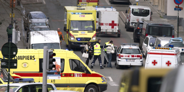 Emergency services evacuate a woman after a explosion in a main metro station in Brussels on Tuesday, March 22, 2016. Explosions rocked the Brussels airport and the subway system Tuesday, killing at least 13 people and injuring many others just days after the main suspect in the November Paris attacks was arrested in the city, police said. (AP Photo/Virginia Mayo)