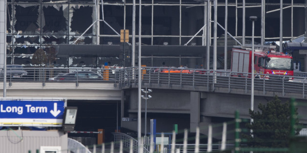 The blown out facade of the terminal is seen as a fire truck drives down the ramp at Zaventem airport, one of the sites of two deadly attacks in Brussels, Belgium, Tuesday, March 22, 2016. Authorities in Europe have tightened security at airports, on subways, at the borders and on city streets after the attacks Tuesday on the Brussels airport and its subway system. (AP Photo/Peter Dejong)