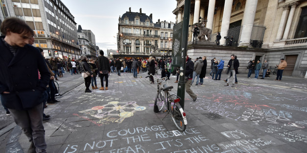 People write hundreds of messages on the asphalt at Place de la Bourse in the center of Brussels to mourn for the victims of todays attack, Tuesday, March 22, 2016. Bombs exploded at the Brussels airport and one of the city's metro stations Tuesday, killing and wounding scores of people, as a European capital was again locked down amid heightened security threats. (AP Photo/Martin Meissner)