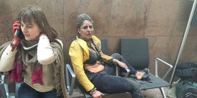 TOPSHOT - RESTRICTED TO EDITORIAL USE - MANDATORY CREDIT 'AFP PHOTO / KETEVAN KARDAVA / Georgian Public Broadcaster An injured woman looks on as another speaks on her mobile phone following twin blasts at Brussels airport in Zaventem on March 22, 2016 as part of co-ordinated attacks claimed by Islamic State group (IS) millitants at the city's airport and in a Metro train.
Airlines cancelled hundreds of flights and European railways froze links with Brussels after a series of bombs blasts killed around 35 people in the city's airport and a metro train, sparking a broad security response. Belgium locked down the capital, home to the headquarters of the European Union and NATO, and imposed its highest level of security alert after the explosions, which extinguished about 20 lives in the metro and another 14 in the airport, according to authorities in Brussels.
/ AFP / Georgian Public Broadcaster / Ketevan Kardava / RESTRICTED TO EDITORIAL USE (Photo credit should read KETEVAN KARDAVA/AFP/Getty Images)