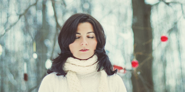 Girl with shut eyes in winter forest