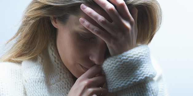 Woman holding her head between her hands