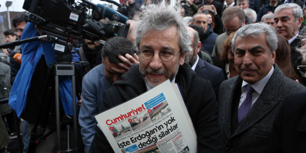 Can Dundar, the editor-in-chief of opposition newspaper Cumhuriyet, center, speaks to the media before the start of his trial in Istanbul, Friday, March 25, 2016. A group of writers, including Nobel laureates, are calling on Turkey to drop charges against two prominent journalists who face life imprisonment for their reports, and to end its crackdown on free expression. Dundar and Erdem Gul, paper's Ankara representative, go on trial on Friday accused of espionage and other charges for their rep